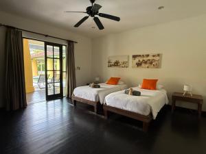 een slaapkamer met twee bedden en een plafondventilator bij Luxury Pool Villa - Sawan - 4 Bedroom in Hua Hin