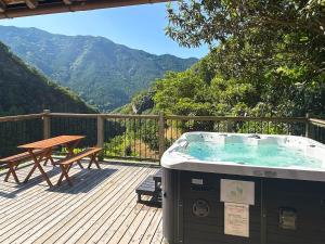 Un jacuzzi en una terraza con una mesa de picnic. en ハイランドビュー, 