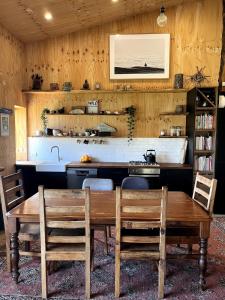 une cuisine avec une table, des chaises et un évier dans l'établissement Stokes Bay Surf Shack, à Stokes Bay