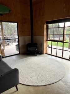 - un salon avec un grand tapis et une cheminée dans l'établissement Stokes Bay Surf Shack, à Stokes Bay