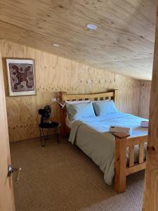 a bedroom with a bed with a wooden ceiling at Stokes Bay Surf Shack in Stokes Bay
