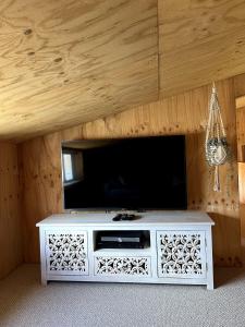 a white entertainment center with a flat screen tv at Stokes Bay Surf Shack in Stokes Bay +13 photos