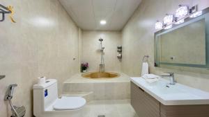 Luxurious Al Danah 5BR Family Friendly Getaway في أبوظبي: حمام مع مرحاض ومغسلة وحوض استحمام