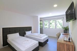 ein Hotelzimmer mit zwei Betten und einem Tisch in der Unterkunft SMARTHOTEL Aalen in Aalen