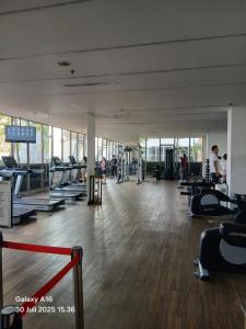 a gym with a lot of treadmills and people exercising at Apartment Studio Gold Coast PIK Tower Carribean in Jakarta