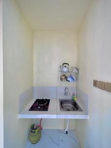 a small kitchen with a sink and a stove at Diiza Glamping in Tawangmangu