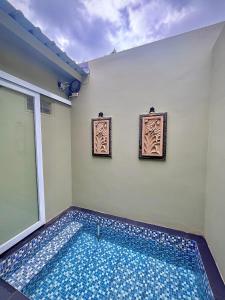 a swimming pool in a room with two pictures on the wall at Diiza Glamping in Tawangmangu +2 photos