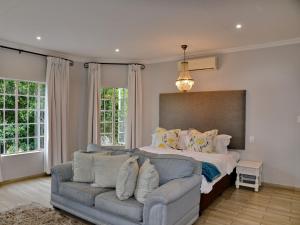 un salon avec un canapé et un lit dans l'établissement ANEW Resort White River Mbombela, à White River