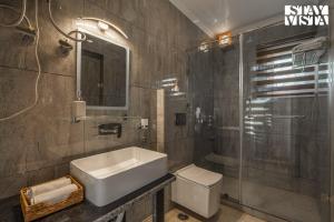 a bathroom with a sink and a toilet and a shower at StayVista at Emaarat Chalet with BBQ & Bonfire in Srinagar +47 photos