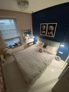 una camera con un grande letto con una persona sdraiata sopra di Komfort House apartament z tarasem a Ełk