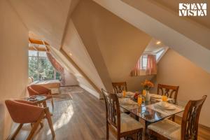 a dining room with a table and chairs at StayVista at Emaarat Chalet with BBQ & Bonfire in Srinagar