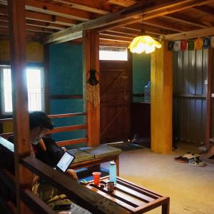 a person sitting on a couch with a laptop at Stargaze Backpackers Ziro in Ziro