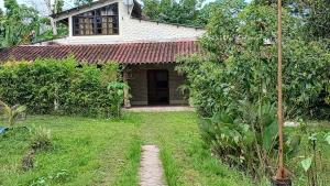 a small house with a red roof in a yard at Casa Alojamiento La Cascina in Iquitos