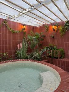 a hot tub in a garden with a roof at kukjejang hotel 