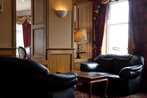 a living room with two leather chairs and a table at The Imperial Hotel in Fort William