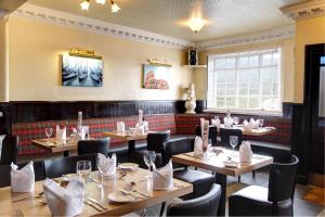 a restaurant with wooden tables and black chairs at The Imperial Hotel in Fort William