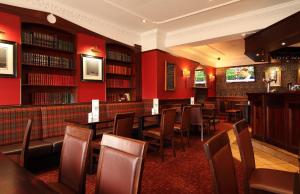een restaurant met rode muren en tafels en stoelen bij The Imperial Hotel in Fort William