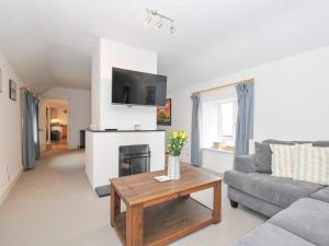 a living room with a couch and a fireplace at Orchard Cottage in Saint Endellion