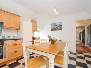a kitchen with a wooden table and chairs in a room at Orchard Cottage in Saint Endellion