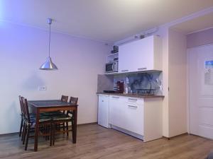 a kitchen with a table and a table and a microwave at Tp Apartman in Tapolca