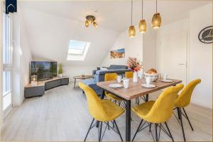 un soggiorno con tavolo da pranzo e sedie gialle di FeWo Kleckerburg a Kolpinsee
