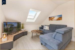 un soggiorno con un divano e una TV di FeWo Kleckerburg a Kolpinsee