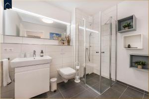 un bagno bianco con wc e doccia di FeWo Kleckerburg a Kolpinsee Altre 32 foto