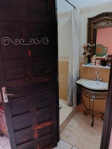 Riad kech residence al Qarya syahiya Marrakech في مراكش: حمام بباب اسود ومغسلة +73 صورة