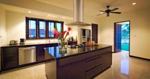 een keuken met een vaas met bloemen op een aanrecht bij Luxury Pool Villa - Sawan - 4 Bedroom in Hua Hin