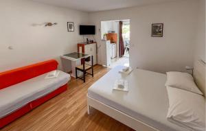 Habitación pequeña con 2 camas y TV. en Beautiful Apartment In Duce With House Sea View, en Duće