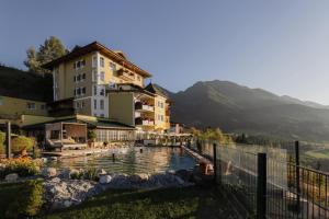 a hotel with a pool in front of a building at Hotel AlpenSchlössl in Sankt Johann im Pongau