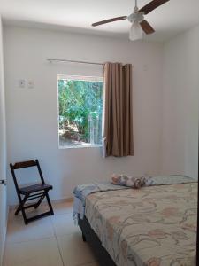 a bedroom with a bed and a chair and a window at Hospedagem Ribeirão do meio in Lençóis