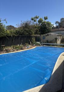 a large blue swimming pool in a yard at a perfect weekend getaway in Rockingham