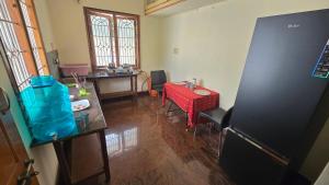 a room with a kitchen with a table and a refrigerator at Eden Garden Homestay in Mysore +5 photos