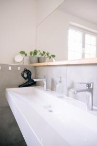 a bathroom sink with two faucets and a mirror at Ferienhaus Glücksgriff Pottenstein in Pottenstein