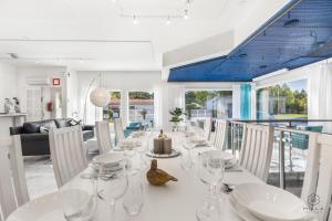 Un comedor con una mesa y sillas blancas. en Kataja Hideaway Residence by Hilla Villas, en Rovaniemi