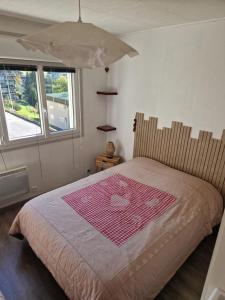 a bedroom with a bed with a pink blanket on it at La Bresse OURSON in La Bresse
