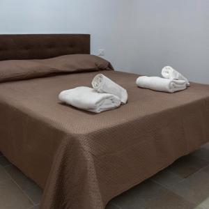 twee handdoeken liggen bovenop een bed bij Lanucara 6 in Martina Franca