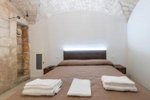 een slaapkamer met een groot bed en 2 witte handdoeken bij Lanucara 6 in Martina Franca