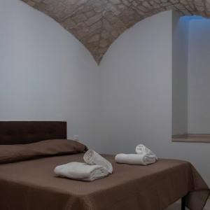 een slaapkamer met een bed met handdoeken erop bij Lanucara 6 in Martina Franca