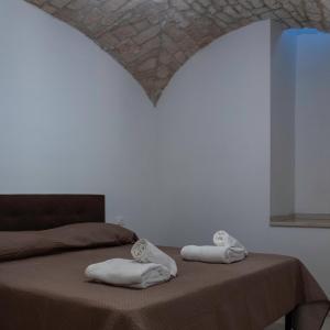 een slaapkamer met een bed met handdoeken erop bij Lanucara 6 in Martina Franca