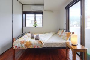 ein Schlafzimmer mit einem Bett mit Schuhen darauf in der Unterkunft Wind Henza - Vacation STAY 73122v in Uruma