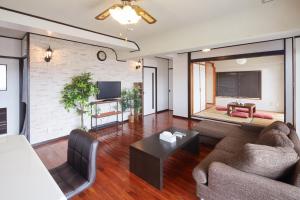 ein Wohnzimmer mit Sofa und Tisch in der Unterkunft Wind Henza - Vacation STAY 73122v in Uruma