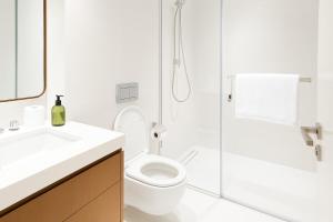 a white bathroom with a toilet and a shower at 2 BR Soul Beach Mamsha Sadiyaat - Partial Sea view in Abu Dhabi +14 photos