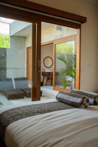a bedroom with a bed and a large window at Niva Sanctuary - Family Friendly 2BR Villa with private pool - Between Sanur & Ubud in Ketewel