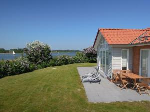a house with a picnic table and chairs on a lawn at Schlei Resort Marina Hülsen in Kosel