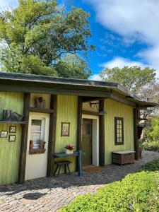 una casa verde con un banco delante en Das Künstlerhaus, en Heideloh