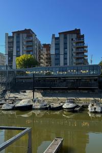 a train on a bridge over a river with boats at Prestige Yacht Resort Budapest in Budapest