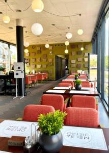 a dining room with red chairs and tables and windows at Prestige Yacht Resort Budapest in Budapest