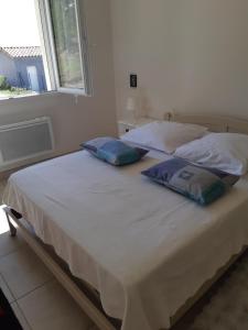 two pillows on a bed in a room with a window at villa soleil in Ruoms